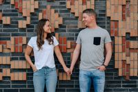Ein verlobtes Paar steht vor einer Steinmauer in der Hamburger Hafencity